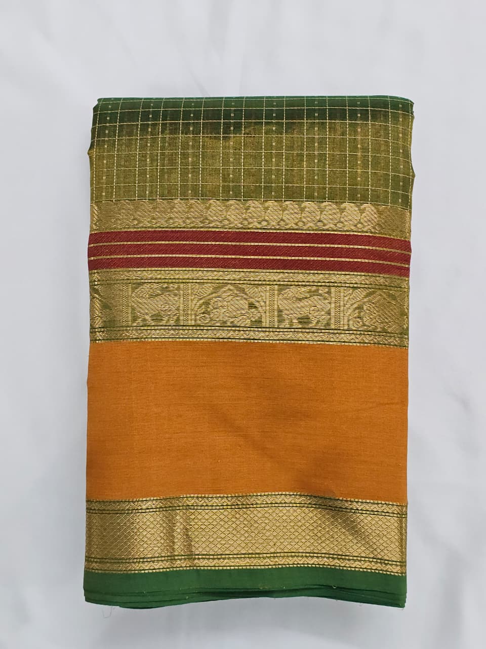 A folded Lakshadeepam Handloom Kanchi Silk Cotton Saree | Forest Green with Mustard-Rust Pallu & Temple Zari Border